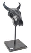 A 20th century plaster cast and resin coated cows / ox skull being ebonised and raised on pole