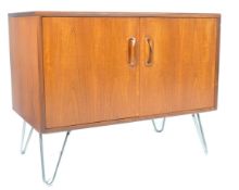 A vintage 20th century retro teak wood G-Plan sideboard dresser being raised on hairpin metal legs