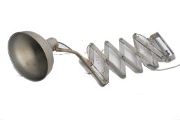 A vintage french polished steel lamp being wall mounted attached to an extending scissor action