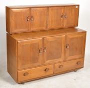 A 20th century light elm and beech wood twin section sideboard dresser by Ercol. Raised on castors