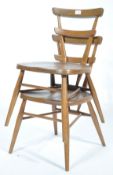 A pair of rare mid century beech and elm wood Ercol ' Green Dot ' stacking chairs. Raised on