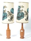 A pair of retro mid 20th century turned teak wood table lamps, each lamp with matching retro