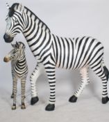 A stunning life-size resin painted grand scale adult female Zebra sculpture together with a Zebra