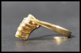 A hallmarked 18ct gold and diamond wishbone ring. The seven round cut diamonds of approx 10pnts each