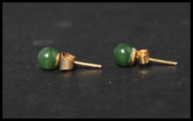 A pair of vintage 9ct gold and jade stud earrings. Jade stone beads set to gold post backs. Weighs