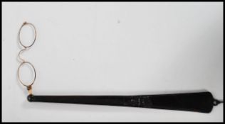 A pair of early 20th century lorgnettes folding opera glasses having yellow metal glasses with a