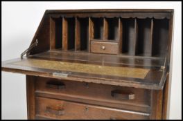 A 1930's Art Deco oak bureau desk raised on ball feet with a bank of drawers under a fall front