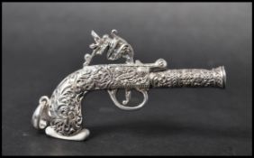A 925 silver novelty pendant in the form of an ornate pistol with bale. Marked London 1795 Sterling.