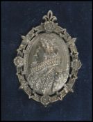 A vintage cast white metal brooch depicting the bust of Elizabeth I with inscription to the