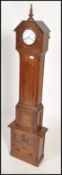 A 19th century oak cased continental  grandmother clock raised on a later built cupboard plinth
