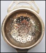 A silver hallmarked tea strainer bearing hallmarks for Birmingham. Weighs 26.6 grams. Measures 14 cm