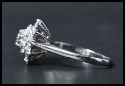 A contemporary  ladies 20th century 18ct white gold diamond cluster ring, together with valuation