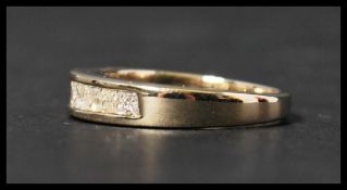 A 14ct gold and diamond half eternity ring set with 9 cushion cut diamonds in a channel setting.