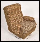 A retro 20th century circa 1970's swivel armchair upholstered in the original fabric and set over