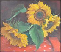 A 20th century still life oil on canvas painting of sunflowers set within a gilt frame and signed to
