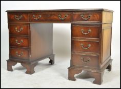 A 20th century antique Georgian revival mahogany and leather twin pedestal writing desk having an