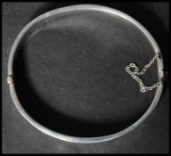 A silver hallmarked vintage ladies bangle bracelet having a half engraved foliate design with hidden