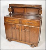 A 1930's Art Deco oak buffet / sideboard. Raised on shaped feet with cupboard above having stage