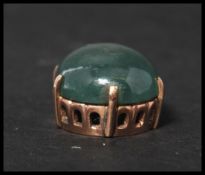 A vintage unmarked but tests as 9ct gold jade pendant. The large jade cabochon set to a pierced gold