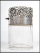 A 19th century Victorian silver hallmarked glass perfume bottle. The scrolled hinged lid opening
