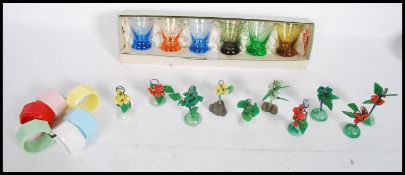 A collection of vintage / retro kitsch to include a set of six multi coloured napkin rings, a set of