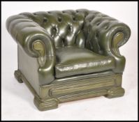 A 20th century Chesterfield green leather button back club armchair, low back with scroll arms.