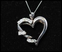 A 14ct white gold and diamond pendant necklace strung with a diamond set heart shaped pendant  on