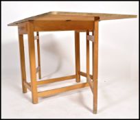 A retro 1950's red formica and beech wood drop leaf harvest table. The red formica top raised on