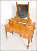 A Victorian 19th century satin birch wood duchess dressing table being raised on turned legs with