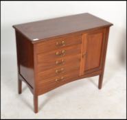 An Edwardian mahogany music cabinet being raised on square tapered legs with a bank of 5 fall