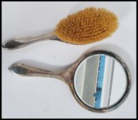 A silver hallmarked matching brush and mirror with monograms. The mirror having a bevelled glass