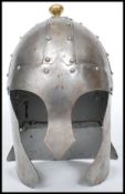 A reproduction Medieval 16th century style helmet of cast metal construction having a hammered and