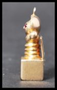 A 9ct gold Jack In The Box charm having ruby stone eyes. Unmarked but tests as 9ct gold, eyes test