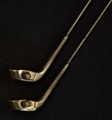 Pair of silver golf club hat pins early c.20th. mounted with guttie golf ball in the face of the