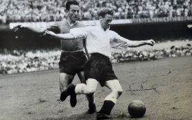 Sir Tom Finney Signed England Football Print a black and white print, depicting Finney evading a