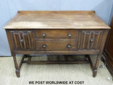 An oak low sideboard with two drawers and linen fold doors (H77 x W114 x D52cm)