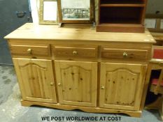 A pine dresser base/ sideboard with three drawers above three cupboards (H91cm x W140cm x D52cm)