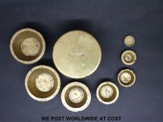 A run of brass nesting cup weights, the lid marked 500 grammes to outside and 200 grammes to inside,