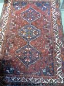 A Turkoman rug decorated with three guls on a wine ground (180 x 119cm)