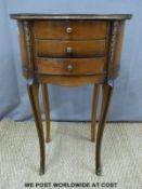 A continental mahogany oval chest of three drawers with ormolu/metal mounts raised on slender