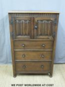 An oak linen fold cabinet over three drawers (H123xW80xD47cm)
