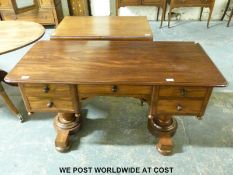 A 19th/20th century mahogany twin pedestal desk raised on two turned supports and four turned feet