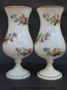 A pair of 19thC white glass vases with hand painted decoration of flowers and gilt banding, 25.