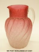 A late 19thC Stourbridge cranberry glass jug of twisted form with crackle finish, 21cm tall.