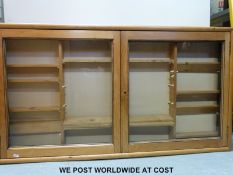 A pine glass-fronted display cabinet with adjustable shelves (H68xW124xD12cm)