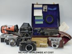 Three boxes of mixed cameras including video, SLRs by Canon, Minolta and Nikon,