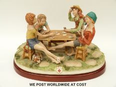 A large Capodimonte figural group of children playing cards 