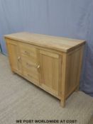 A contemporary light oak sideboard fitted with three drawers and two cabinets (H86 x W137 x D45cm)