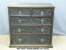 An 18th/19thC oak chest of two over three graduated carved drawers with brass mask drop handles on