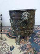 A copper and brass log or coal bin with iron mask handles,